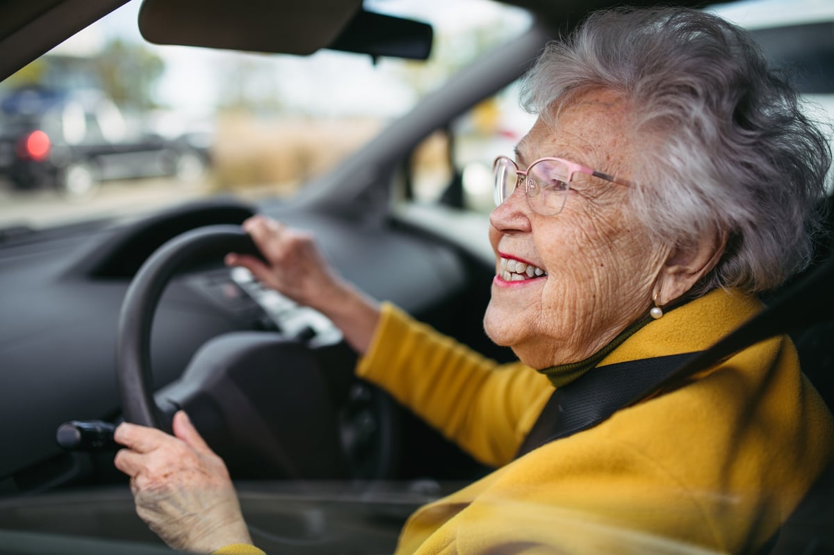 Happy senior woman driving a car, enjoying the ride